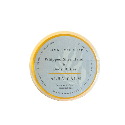 Round container of Damn Fyne Soap’s Alba Calm Whipped Shea Hand & Body Butter, featuring a soft grey label with gold border. Scented with lavender and cedar essential oils, designed for calming and moisturising skin.