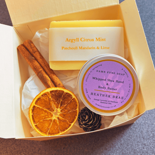 Damn Fyne Soap gift box featuring guest-size Argyll Citrus Mist soap and Heather Brae body butter. Presented with navy ribbon and festive styling using dried orange