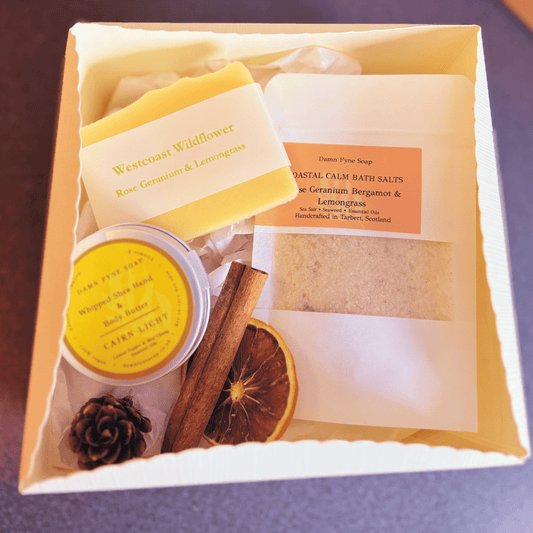 Damn Fyne Soap gift box featuring Westcoast Wildflower soap, Cairn Light body butter, and bath salts with rose geranium, bergamot & lemongrass. Presented with navy ribbon and festive styling