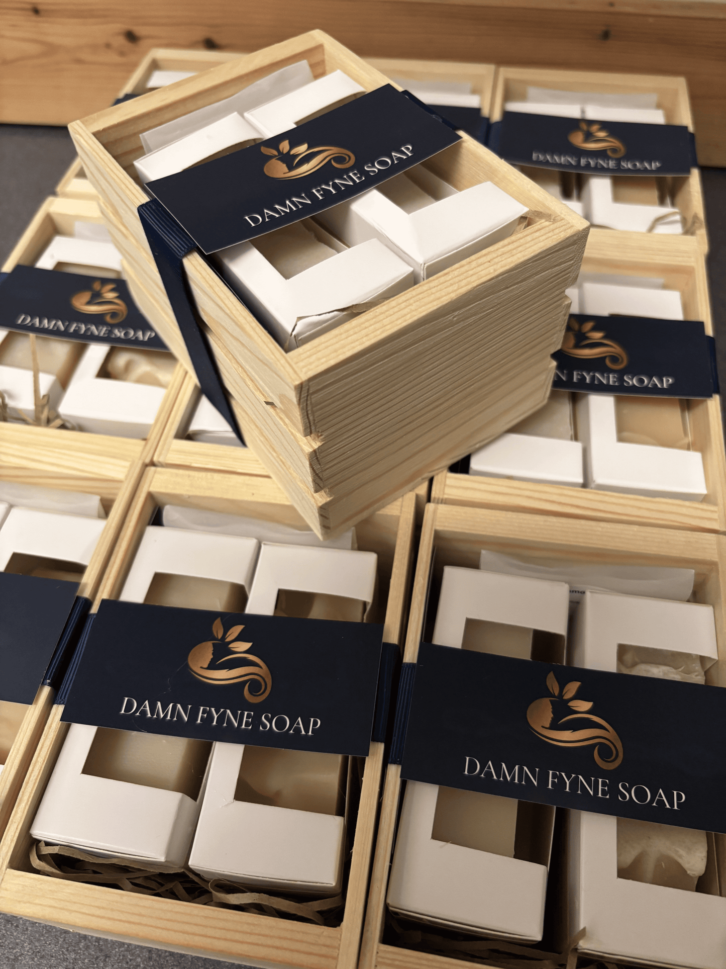 Wooden Damn Fyne Soap gift crate with navy ribbon, containing Argyll Citrus Mist and Fyne Spice Drift, plus a soy wax melt with patchouli & neroli.