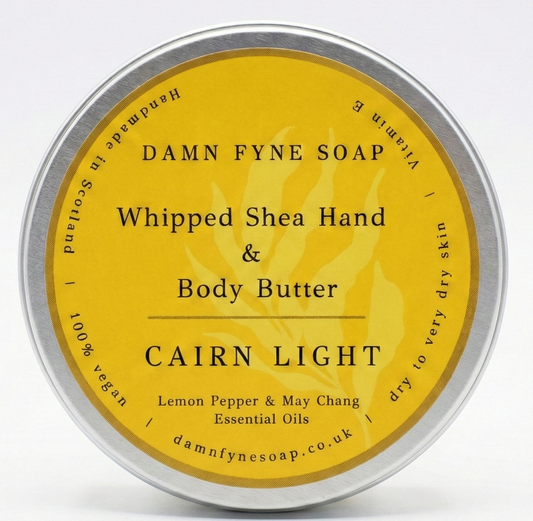 Bright yellow-labeled container of Damn Fyne Soap’s Cairn Light Whipped Shea Hand & Body Butter, scented with lemon pepper and may chang essential oils. Handmade in Scotland.