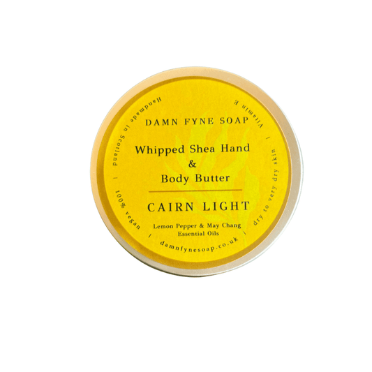 Bright yellow-labeled container of Damn Fyne Soap’s Cairn Light Whipped Shea Hand & Body Butter, scented with lemon pepper and may chang essential oils. Handmade in Scotland.