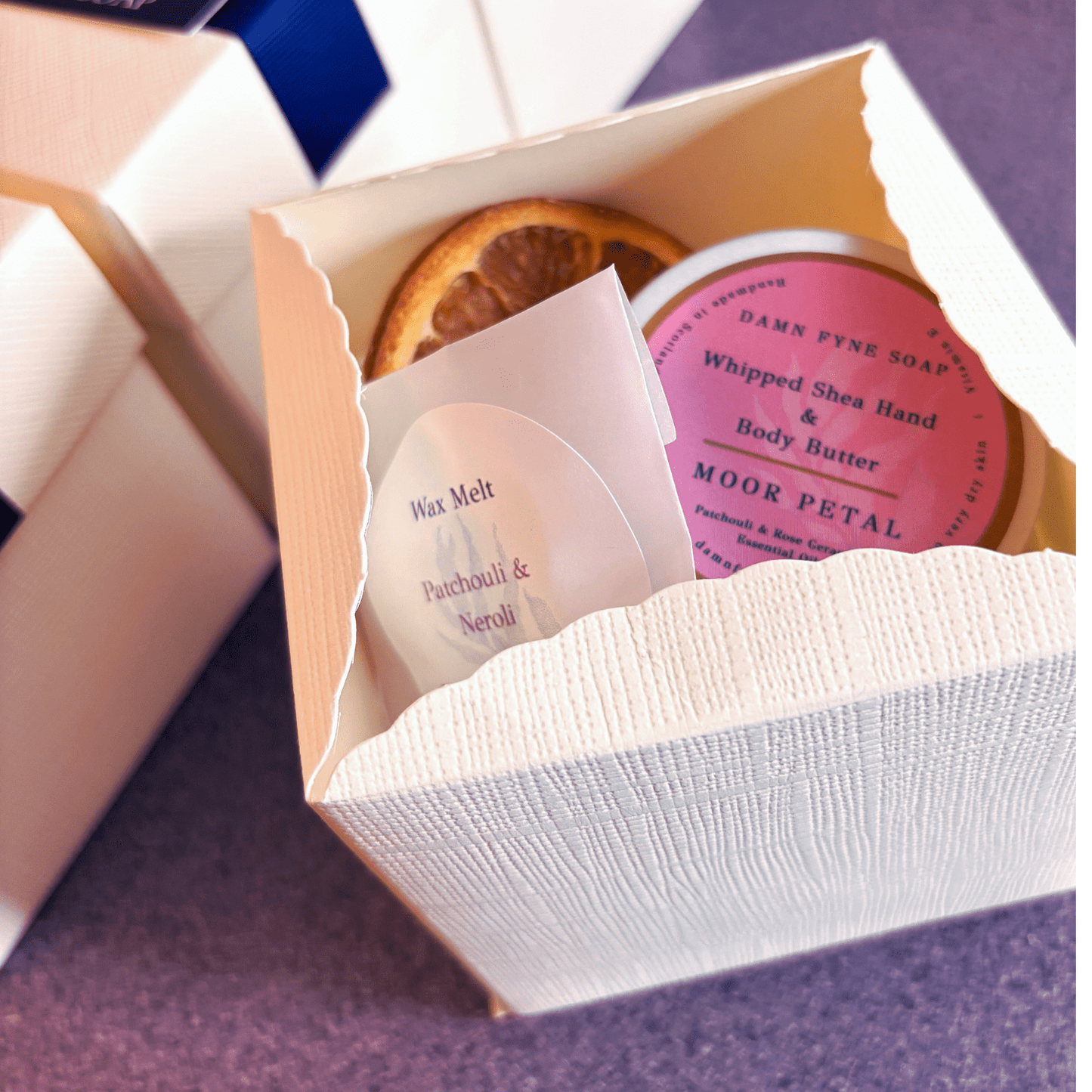 Festive gift box with Moor Petal body butter and patchouli & neroli wax melt. Vegan, handmade in Argyll. Styled for Christmas gifting.