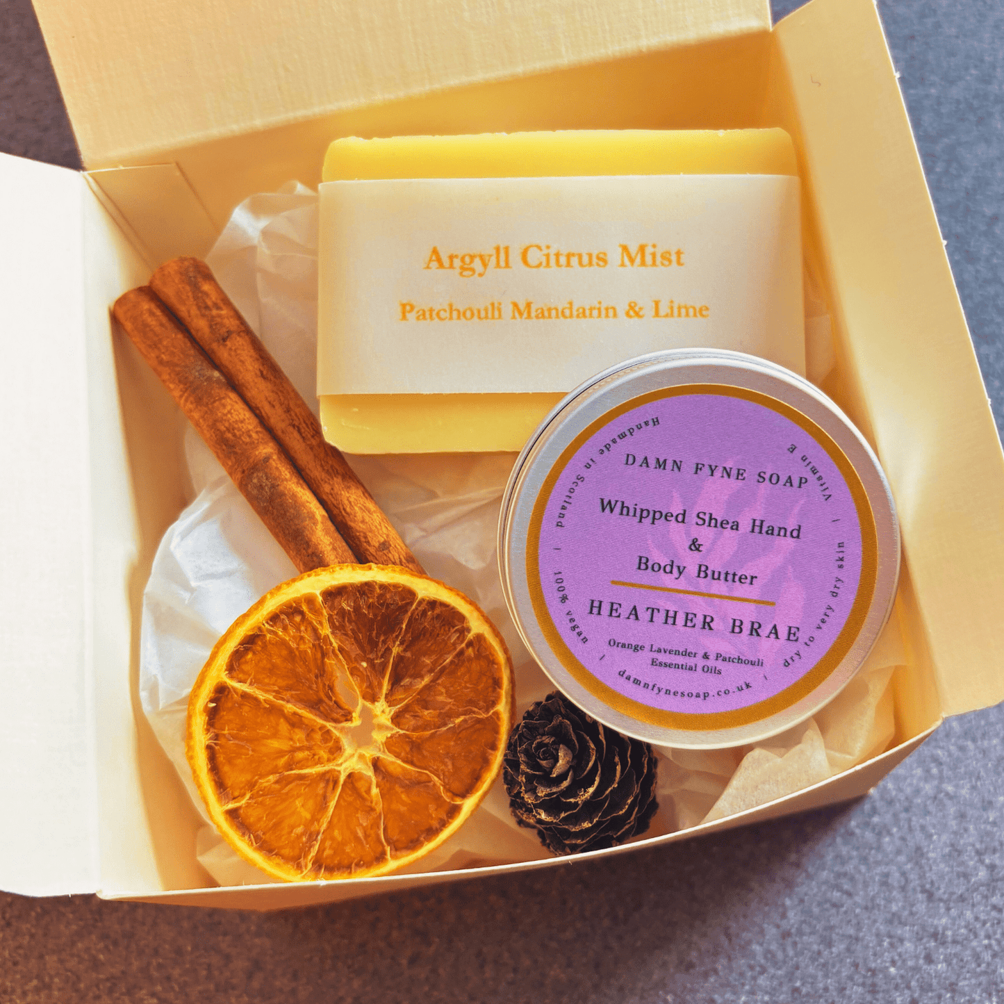 Damn Fyne Soap gift box featuring guest-size Argyll Citrus Mist soap and Heather Brae body butter. Presented with navy ribbon and festive styling using dried orange 