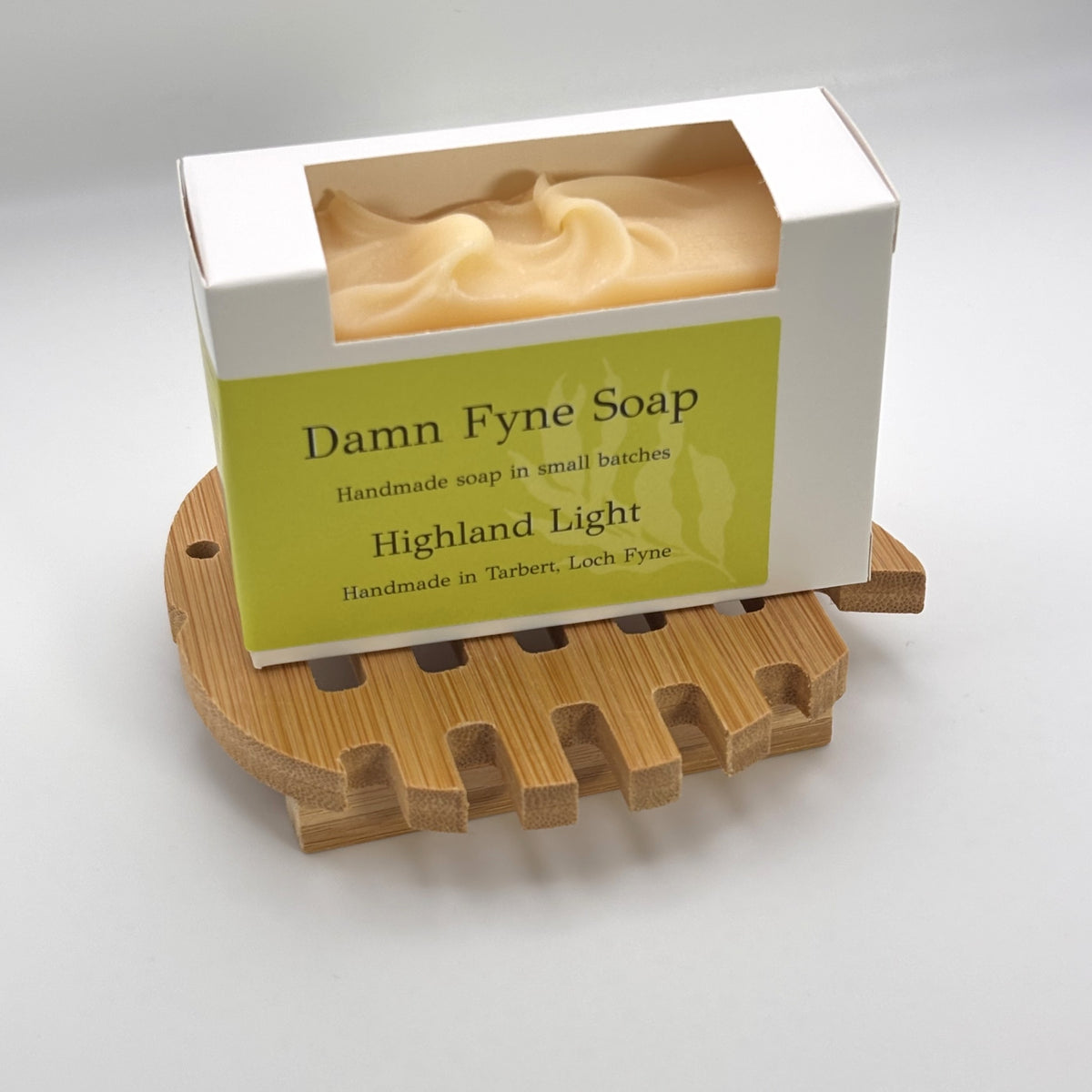 Highland Light handmade soap in its box on a round bamboo soap dish