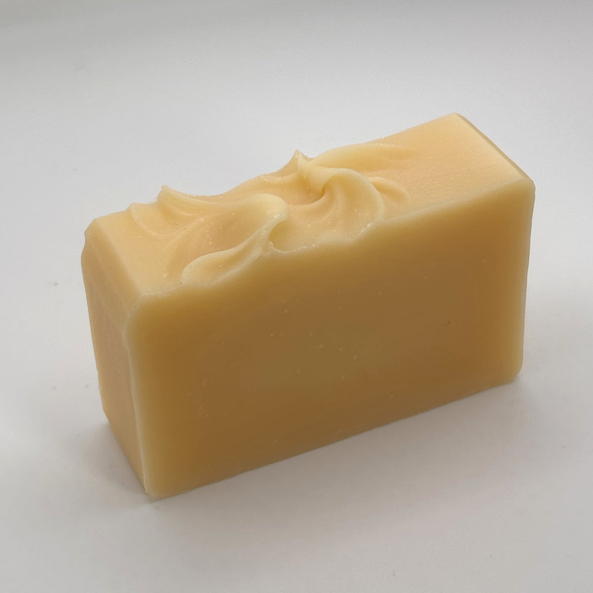 Unwrapped Highland Light handmade soap bar showing its natural colour and hand-finished swirled top.