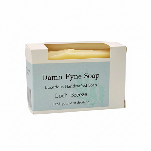 Loch Breeze handmade soap bar in biodegradable kraft packaging with a soft blue label. Label reads “Damn Fyne Soap – Luxurious Handcrafted Soap – Loch Breeze – Hand-poured in Scotland.” Pale-toned soap visible above the box, photographed on a neutral background. lavender and spearmint essential oils