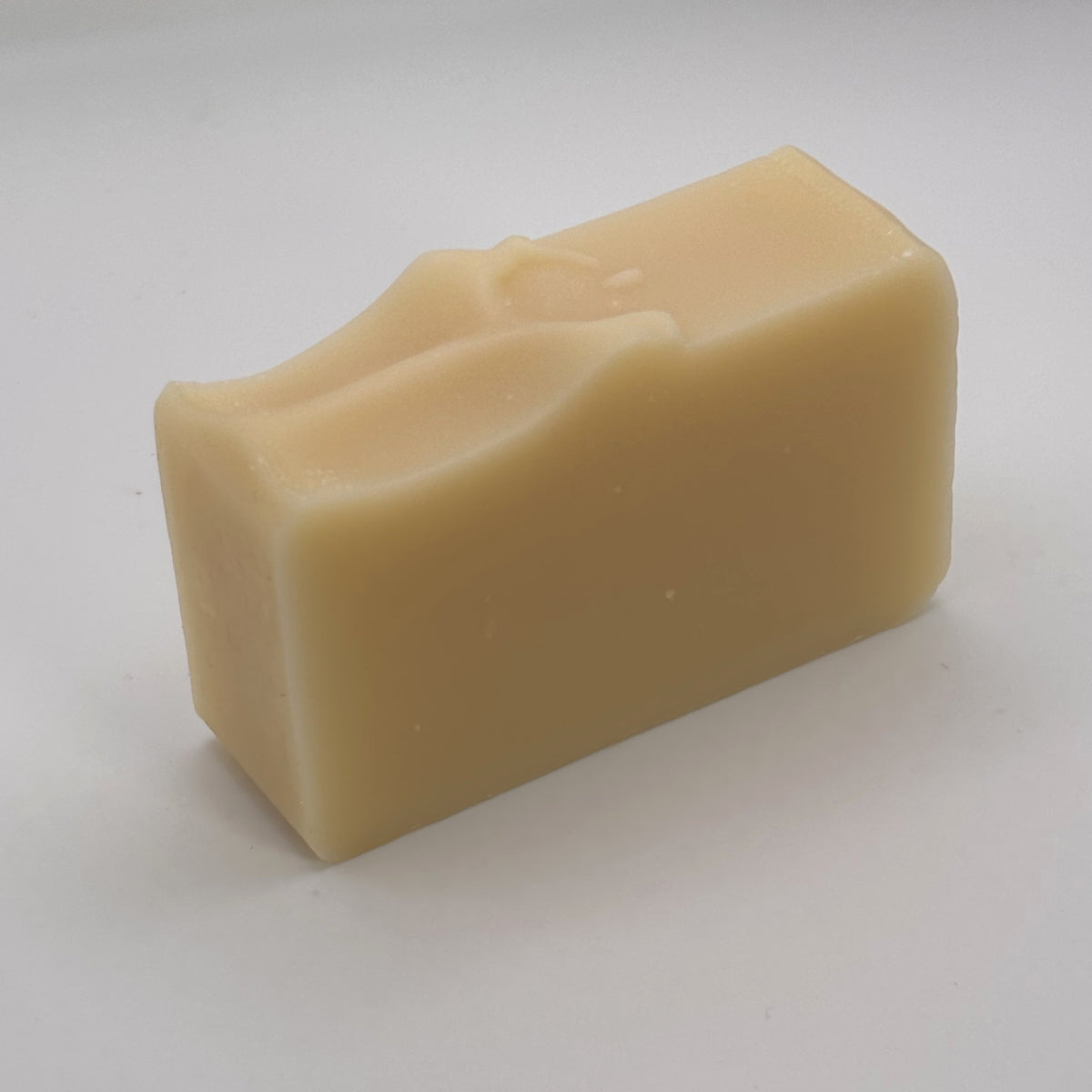 Unwrapped Loch Breeze handmade soap bar, showing its natural colour and hand-finished top.