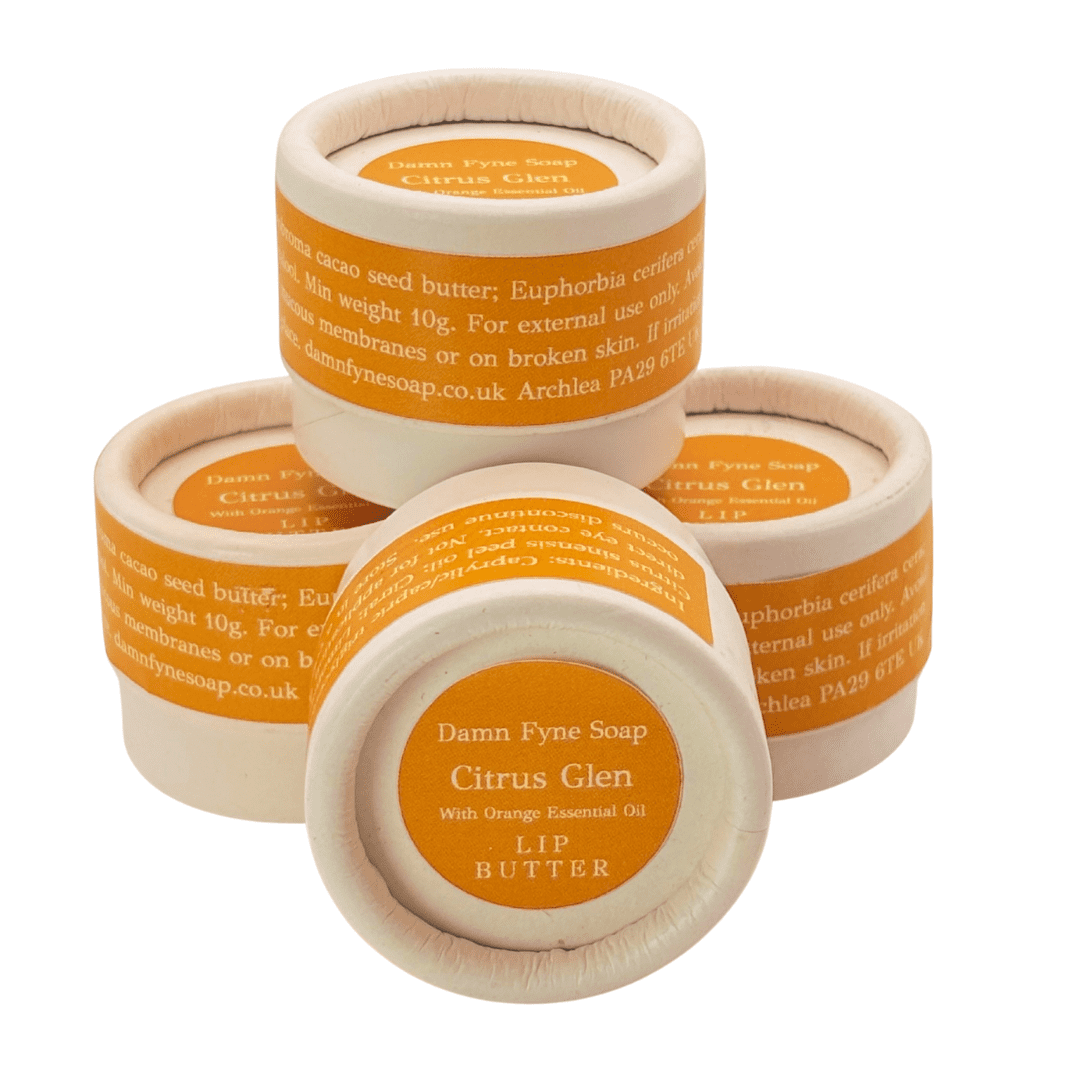 Stack of Citrus Glen Lip Butter pots showing biodegradable packaging and handmade Scottish lip balm.