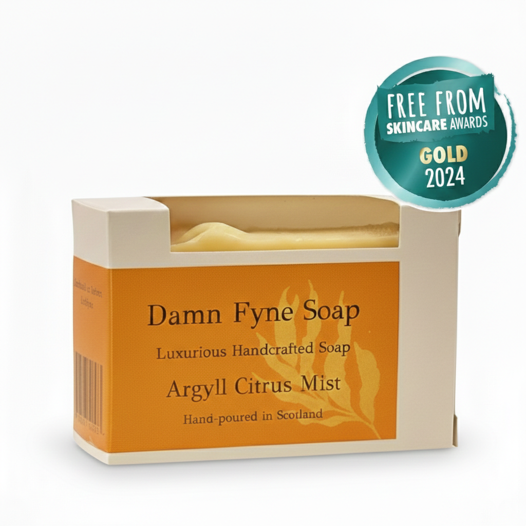 Argyll Citrus Mist handmade soap bar in a kraft box with orange label. Light yellow soap peeks above the packaging. Label reads “Damn Fyne Soap – Luxurious Handcrafted Soap – Argyll Citrus Mist – Hand-made in Scotland.