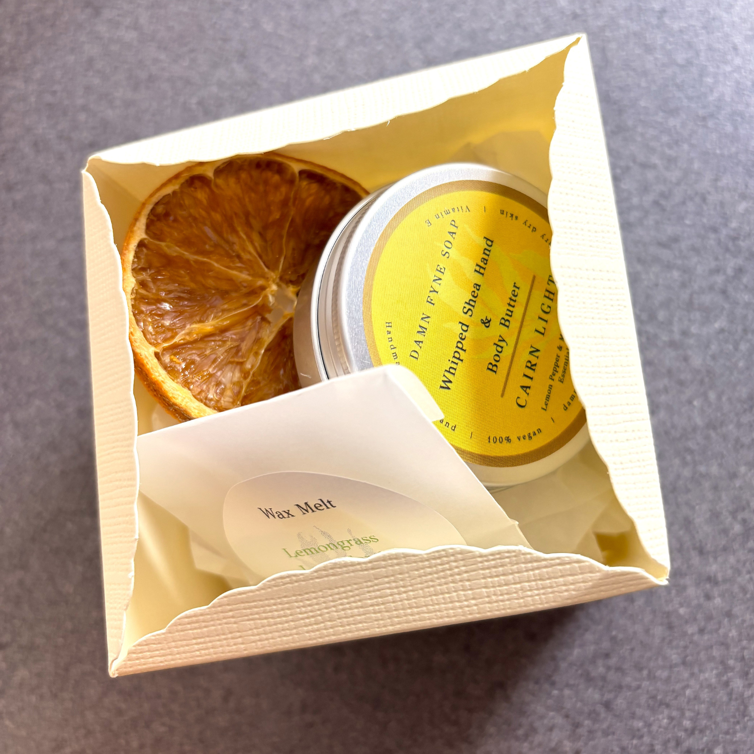 Christmas gift box with Cairn Light body butter and citrus wax melt. Vegan, handmade in Argyll. Styled with dried orange slice.