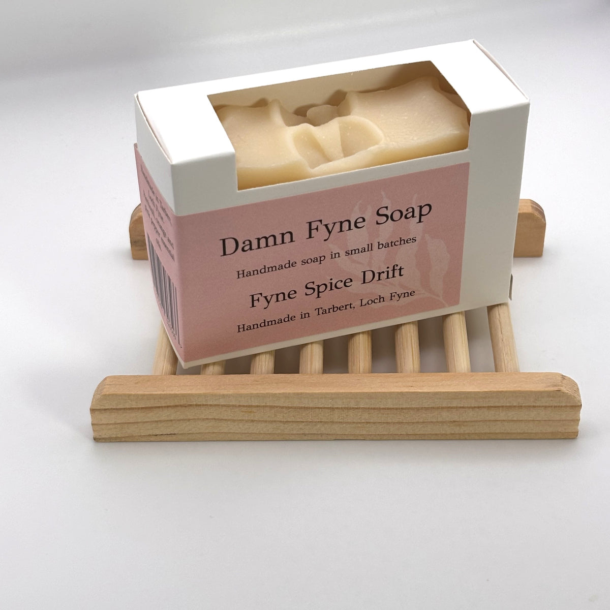 Fyne Spice Drift handmade soap in its box on a natural wooden soap dish