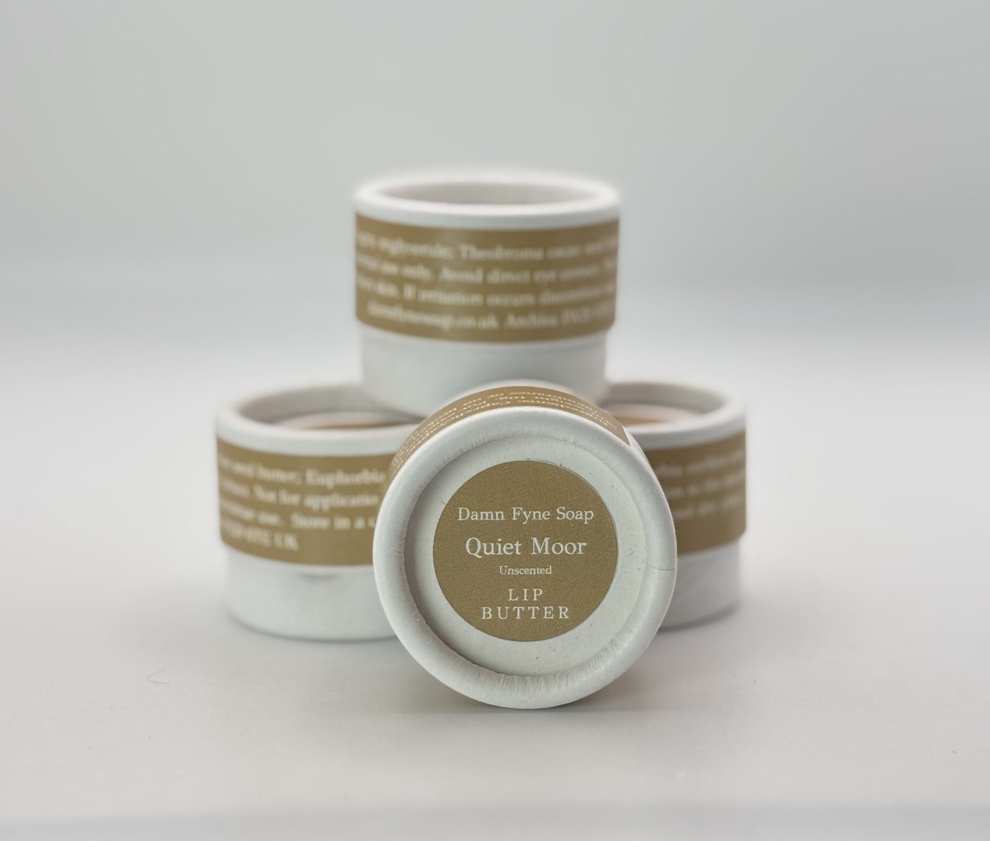 Stack of Quiet Moor Lip Butter pots showing biodegradable packaging and handmade unscented lip butter.